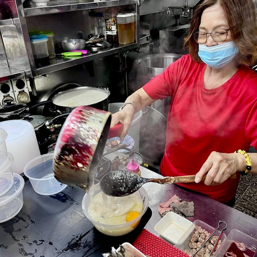 Ming Kee's owner ladling fresh porridge to order, steam rising